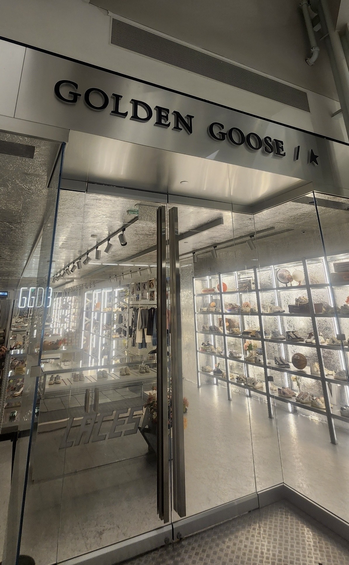 Golden Goose retail storefront installation featuring frameless glass doors, custom metal framing, and premium glazing in a luxury retail environment